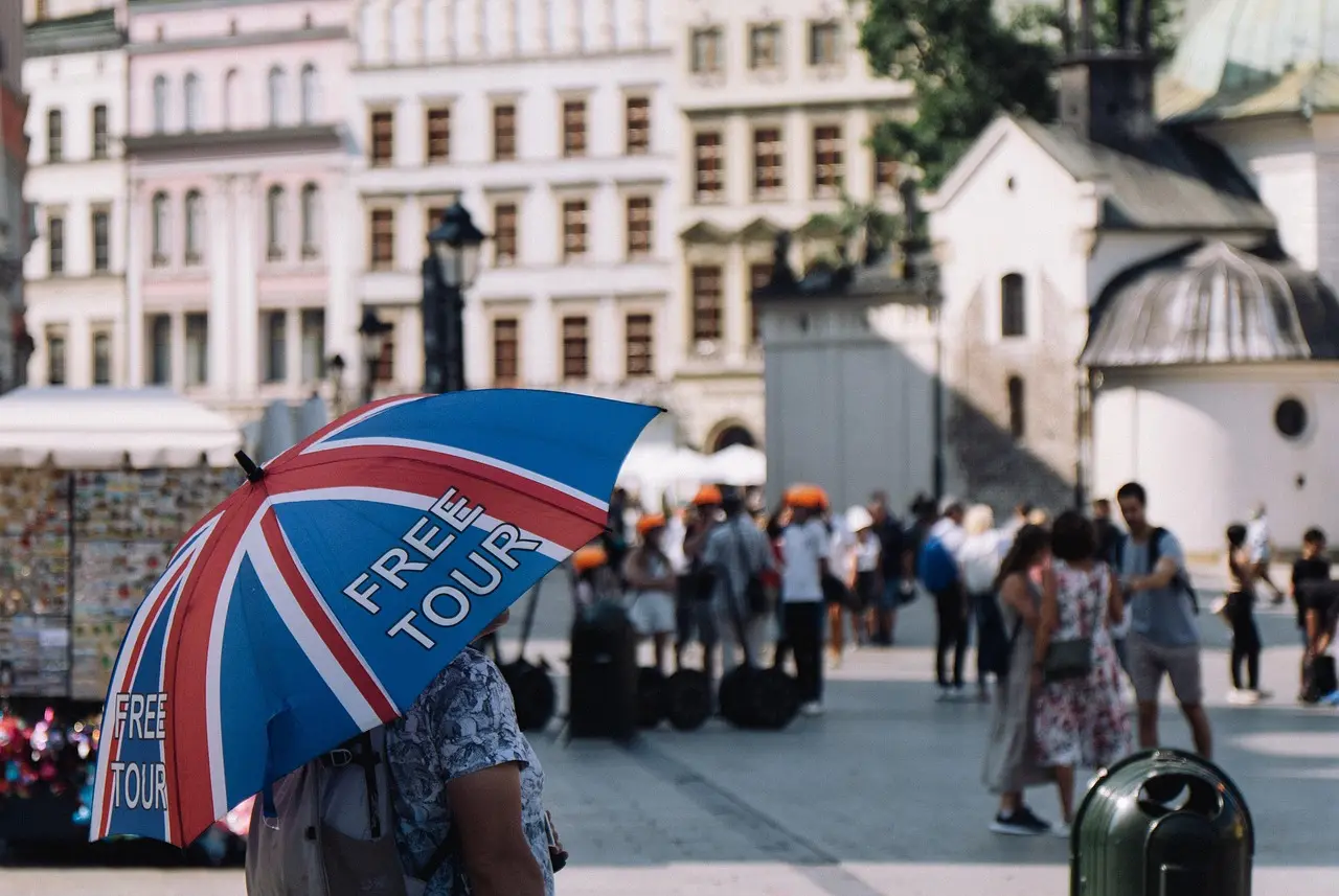 Grupo de turistas siguiendo a un guía en una calle de Londres con bandera